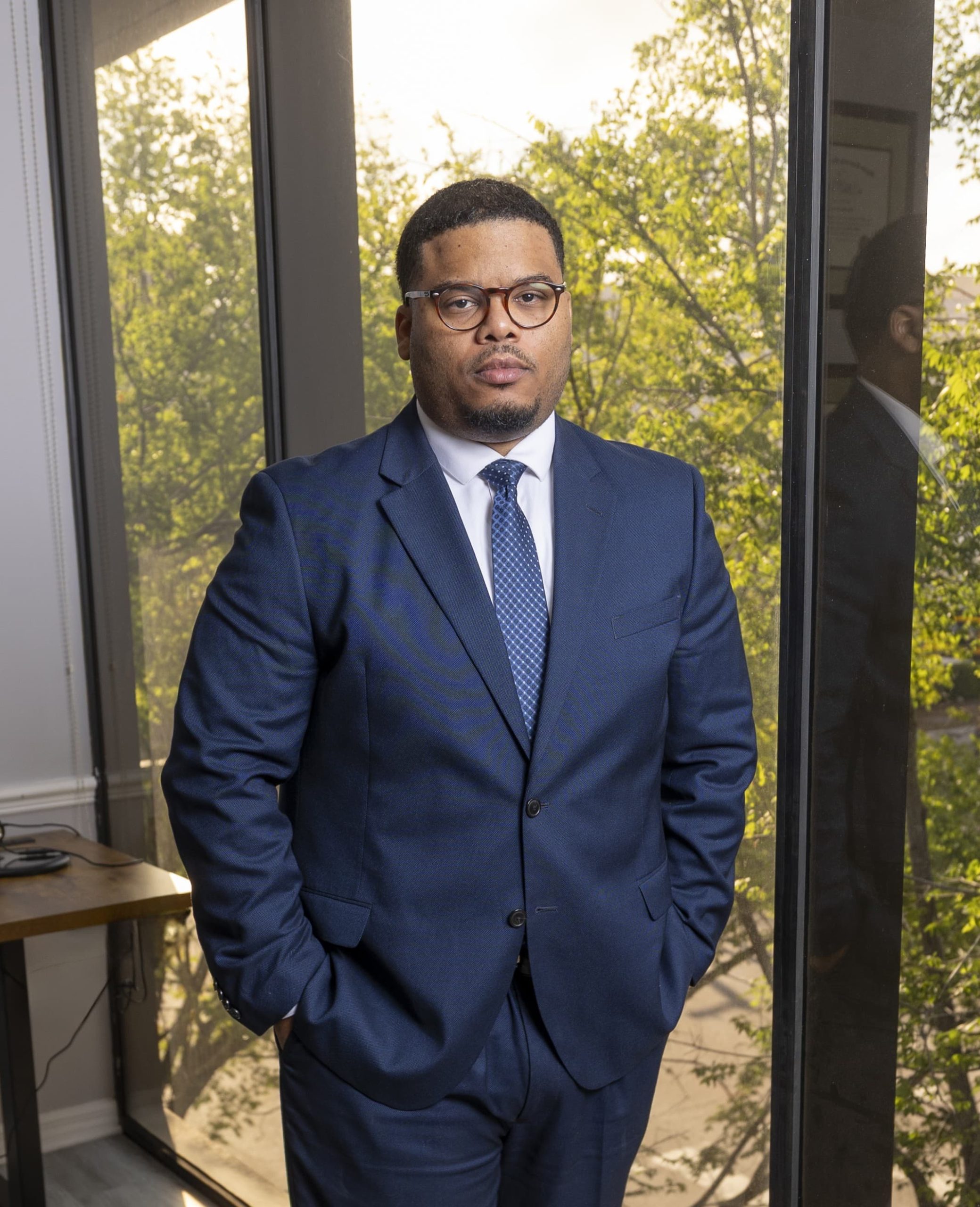 Photo of Tampa Attorney Jean-Luc Adrien Standing by his office window.